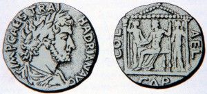 מטבע של איליה קפיטולנה עם דמותו של אדריאנוס. מאחור דמות מקדש עם דמותם של שלשת האלים הקפיטולינים